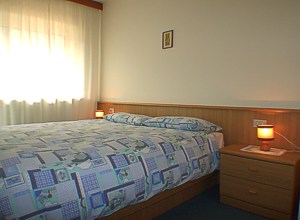 Apartment in Canazei. Master bedroom with balcony facing south.
