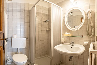 Wohnung - Canazei. kleines Badezimmer mit Waschbecken, Dusche, WC und Haarfön