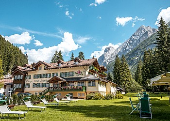Hotel 3 stelle a Canazei (***) a Canazei. L’Hotel è in una posizione tranquilla, distaccato dalla strada principale e dal traffico ed è situato all’interno di un grande parco naturale
di proprietà UNICO IN VALLE!! (10.000 metri quadri di giardino e abeti) adiacente lungo le sponde del Fiume Avisio, attrezzato con
tavoli, ombrelloni e lettini a sdraio, ottimi per il relax, inoltre un piccolo campo da bocce e da pallavolo, una chiesetta consacrata sempre aperta a
tutti con funzioni religiose, un ampio parcheggio interno scoperto e custodito, un Garage per auto e moto.
Siamo a 30 metri dalla pista pedonale e ciclabile che comodamente in 10 minuti di passeggiata collega il Centro di Canazei e a 60 metri dall’impianto delle
Funivie del Ciampac e dalla Val Contrin dove potrete godervi paesaggi incantevoli ed effettuare gite naturalistiche adatte per Adulti e Bambini.