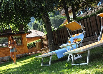 Privati a Moena. giardino attrezzato con lettini e giochi per i bambini
