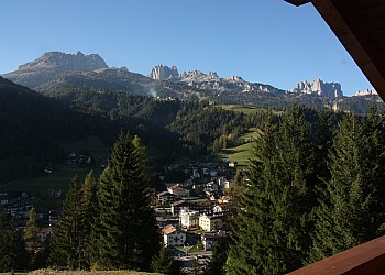 Appartamento a Soraga. La mansarda offre un doppio affaccio con ampi balconi che guardano, a monte verso cima Dodici e Sass Aut, e a valle, verso il centro di Soraga e, sullo sfondo, il gruppo del Catinaccio con la Roda di Vael.