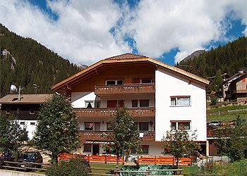 Appartamento a Canazei. La nostra casa  è situata nella zona est di Canazei in posizione tranquilla e soleggiata ; il centro paese non dista più di 3 minuti a piedi. Altrettanto vicina è anche la stazione a valle della cabinovia Canazei-Pecol, impianto questo che permette poi di raggiungere in breve tempo l'area del Belvedere punto di partenza per escursioni al Passo Pordoi, al Sass Pordoi nonchè al comodo, famoso sentiero 