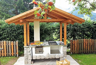 Residence a San Giovanni di Fassa - Pera. È a disposizione il barbecue in pietra con annesso gazebo e tavolone in legno per gustare meravigliose grigliate in compagnia all'aria aperta.