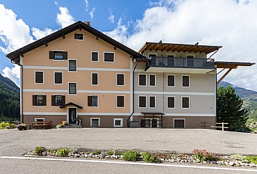 Appartamento a Moena. Questa è la nostra casa, al primo piano a sinistra, con i fiori alle finestre: qui ci siamo noi. L'appartamento invece è nella parte destra, al piano terra la parte giorno e al primo piano la parte notte, qui nascosta dagli alberi. Siamo nella frazione di Someda. Dall'altra parte della casa si gode un'ottima vista su Moena. Il parcheggio è privato. Siamo a 2 chilometri dagli impianti di Lusia-Bellamonte e a 13 circa da San Pellegrino-Falcade.