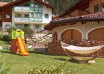 Appartamento a Mazzin - Fraz. Campestrin. Villa Marta dispone di un ampio parcheggio ma anche di un bel giardino completamente recintato e attrezzato con ping-pong, calcetto, cesto da pallacanestro, dondolo, amaca, giochi per bambini, porta-biciclette, barbecue, tavolo con ombrellone, sedie e sedie sdraio per prendere il sole in tranquillità.