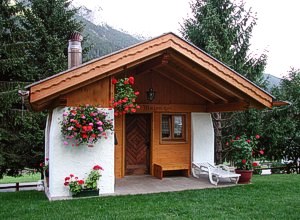 Appartamento a San Giovanni di Fassa - Vigo. La baita è stata realizzata nel giardino posteriore della casa; al suo interno vi è un tavolo con 12 posti per poter pranzare e un angolo cottura.
Il camino esterno consente di poter preparare grigliate in famiglia e tra amici.