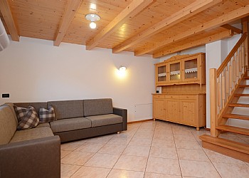 Residence a Campitello di Fassa. Una scala interna porta al piano superiore dove si trovano 2 camere da letto.