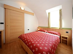 Apartment in Soraga. This is a picture of the double-room with a beautiful view over Soraga and the Lusia Alp.