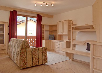 Appartamento a Soraga di Fassa. Il salotto, come del resto tutti gli altri ambienti, sono particolarmente curati nell'arredo. Si tratta di realizzazioni artigianali in legno.