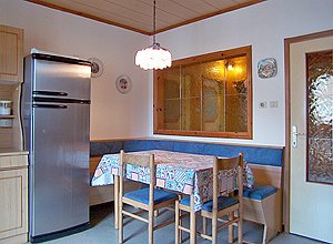 Appartamento a Moena. Posta a sud, la cucina dà direttamente sul poggiolo ed è collegata attraverso una porta con un ampio ingresso.