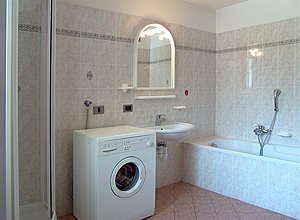 Appartamento a Moena. L'ampio bagno, è dotato di vasca da bagno, doccia, lavatrice e servizi igienici.