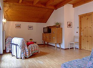 Appartamento a Campitello di Fassa. Spazioso soggiorno con pavimento in legno, TV-SAT e divano letto