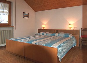 Appartamento a Campitello di Fassa. Camera doppia, luminosa, pavimento in legno con possibilità sia di letto matrimoniale che singoli