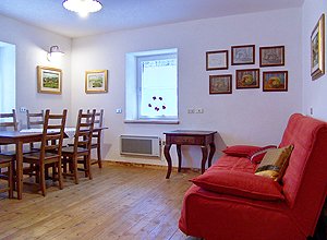 Appartamento a Penia di Canazei. Il soggiorno dispone di divano letto matrimoniale, angolo televisione e vista panoramica sul Gran Vernel.
