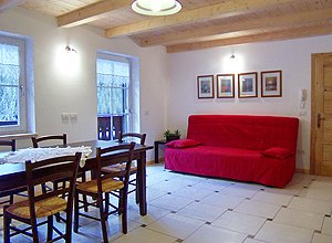 Appartamento a Penia di Canazei. Il soggiorno dispone di divano letto matrimoniale, angolo televisione e balcone con vista panoramica.
