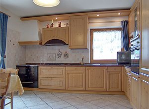 Appartamento a Pozza di Fassa. La cucina dispone di lavastoviglie e tv , vi è anche un piccolo divano,si può accedere alla terrazza.