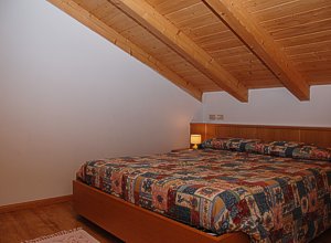 Apartment in Moena. Double room comfortable and rustic sleeping area.