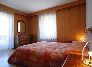 Appartamento a San Giovanni di Fassa - Pozza. Camera matrimoniale elegante e luminosa con finestra e balcone.