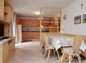 Appartamento a San Giovanni di Fassa - Pozza. L'ampio soggiorno è collegato alla cucina, è molto luminoso ed accogliente.