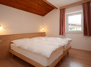 La Villetta - Ein Schlafzimmer mit drei Betten und Badezimmer mit Duesche.