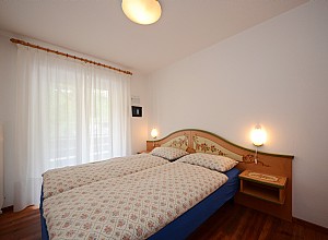 Appartamento a Canazei. Camera matrimoniale, letto non divisibile,arredata in stile ladino. Cassaforte a combinazione numerica.
