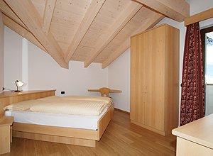 Appartamento a Soraga di Fassa. L'altra camera da letto (anch'essa matrimoniale o con letti singoli) è caratterizzata dalla posizione angolare del letto che conferisce alla stanza una particolarità nuova e diversa dalla solita sistemazione. Il riposo è particolarmente piacevole, reso confortevole dai caldi piumini di cui le stanze sono dotate