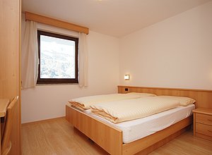 Appartamento a Soraga di Fassa. I pavimenti in legno così come l'arredamento in stile montano conferiscono alle camere una particolare, calda ed accogliente atmosfera.
I piumoni di cui sono dotate richiamano l'antico stile fassano degli ambienti.