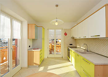 Appartamento a Moena. Il locale cucina è arredato in stile moderno sui toni del verde. Dispone di frigorifero con freezer, lavello a 2 vasche, piano cottura in vetroceramica, forno.
Due porte finestre lo rendono molto luminoso, vi sono inoltre 2 balconi che permettono di avere una vista panoramica su Moena.