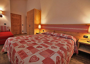 Appartamento a Canazei. Luminosa stanza da letto con letto matrimoniale e all' occorrenza comodo divano letto singolo.
La stanza dispone di cassaforte elettronica e mini frigorifero.
Biancheria da letto compresa nel prezzo.