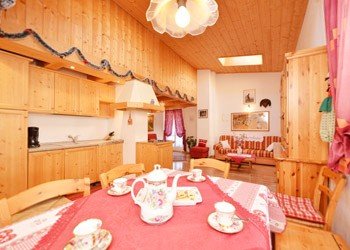 Chalet Tobià de Vale - Wohnung Azola da mont 
Wohnzimmer mit Tisch fuer 8/10 Personen und Kuechenecke