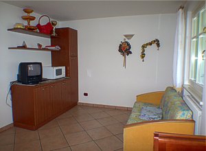 Residence a Campitello di Fassa. App.1: angolo soggiorno con divano letto, televisore, microonde.