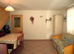 Residence a Campitello di Fassa. Angolo del soggiorno dell'app.to nr. 2 con divano letto, televisore con satellite e videoregistratore.