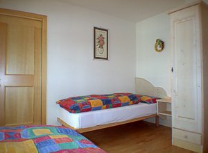Residences in Campitello di Fassa. Second bedroom of the apartment nr. 2 upstairs  with 2 single bed, a bath with shower and balcony