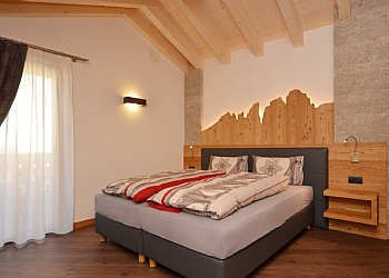 Appartamento a Campitello di Fassa. Spaziosa camera al piano superiore con bagno in camera e possibilità di uso divano letto.