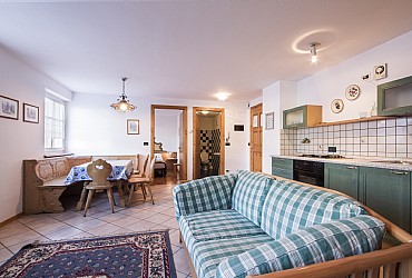 Wohnung - Moena. Kochecke mit Gasherd, Ofen, Kuehlschrank.