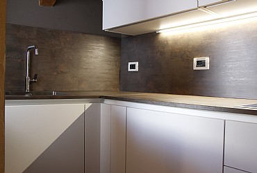 Wohnung - Moena. Kochecke mit Gasherd, Ofen und Kuehlschrank.