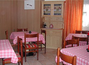 Appartamento a Moena. Al pianterreno, la sala da pranzo, comoda e ampia per 20 persone e a fianco il salotto con TV-sat