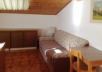 Apartment in Soraga di Fassa. Attic flat, situated on the top floor, 70 square meters, consists of two bedrooms, two bathrooms, large living room with dining area and kitchen area. It has a typical mountain style warm and welcoming, very relaxing.