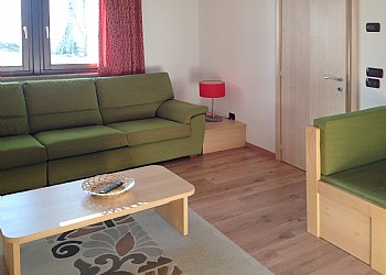 Apartment in Soraga di Fassa. The living-room with two overview windows. The wooden floor is particolary appreciated.
