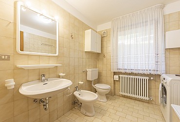 Appartamento a Moena. Ampio e pulitissimo bagno finestrato, con vasca fornita di box per fare la doccia e lavatrice.
