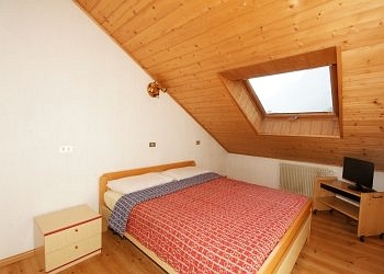 Appartamento a San Giovanni di Fassa - Pozza. Camera matrimoniale nella mansarda sinistra, con una fantastica visuale sulla pista illuminata Alloch.