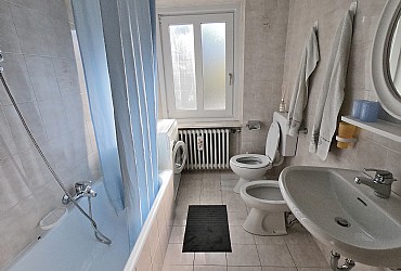 Apartment in Canazei. Bathroom with window, bathtub and wash machine.