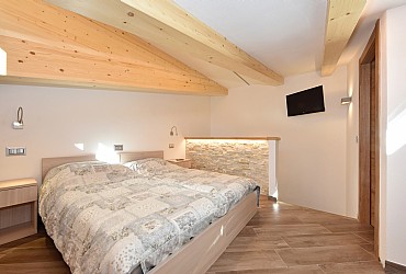 Appartamento a Campitello di Fassa. SECONDO PIANO. Camera  matrimoniale  ( con letti separabili) con tv e poltrona letto.