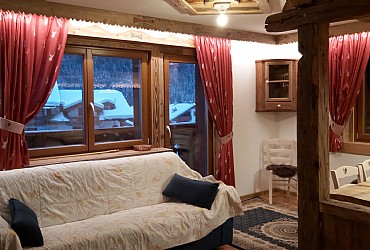 Apartment in Canazei. Living-room is spacious and bright with TV-SAT, table, sofa and an armchair.