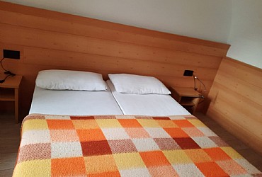 Appartamento a Soraga di Fassa. La camera matrimoniale con vista verso il paese di Soraga e l'Alpe Lusia
