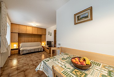 Appartamento a Canazei. la cucina è composta da angolo cottura, tavolo e divano ed è molto luminosa