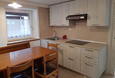 Appartamento a Canazei. Cucina completa con piano cottura ad induzione, forno a microonde, lavastoviglie e televisore digitale.