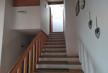 Appartamento a Moena. Comoda scala che porta alla zona notte, in cui ci sono 2 stanze d letto, una doppia e una tripla e un bagno con doccia