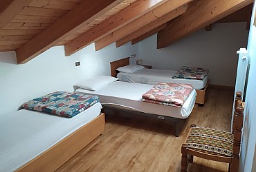 Appartamento a Moena. Camera tripla spaziosa nella zona notte, stile rustico.