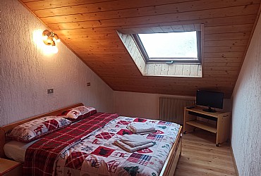 Appartamento a San Giovanni di Fassa - Pozza. Camera matrimoniale, con una visuale sulla pista illuminata Alloch.